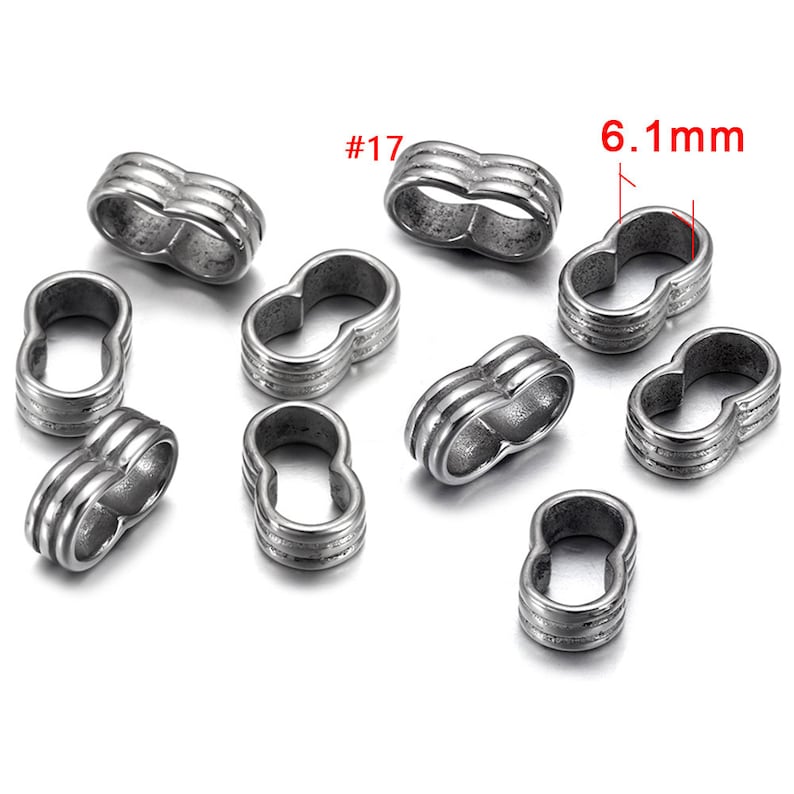 May include: Ten silver-toned metal spacer beads with a double-loop design. Each bead measures 6.1 mm in diameter. The beads are labeled #17.