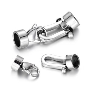 May include: Silver-toned metal clasp with a hook and loop closure. The clasp has a cylindrical end cap on each side.