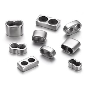 May include: A set of silver metal bead caps with two holes. The bead caps are in various shapes, including round, oval, and rectangular.