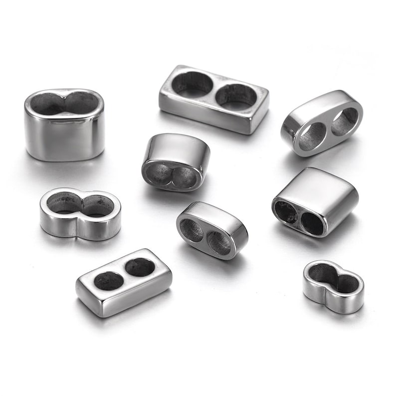 May include: A set of silver metal bead caps with two holes. The bead caps are in various shapes, including round, oval, and rectangular.