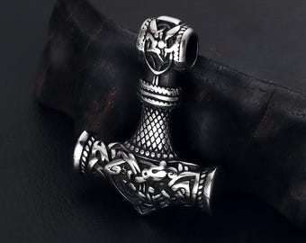 May include: A silver-toned pendant in the shape of a hammer with intricate knotwork and a dragon design. The pendant is a popular symbol of Norse mythology.