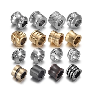 May include: Assortment of 14 metal beads in various styles and finishes, including silver, gold, and black. The beads are all round with a hole in the centre for threading.