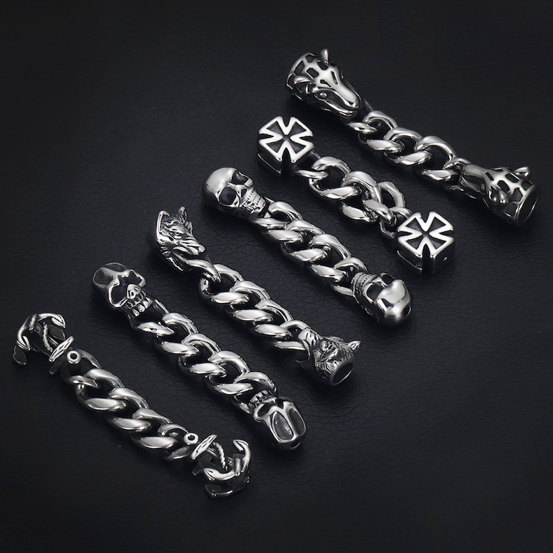 May include: A set of eight silver charm bracelet links featuring various designs, including skulls, crosses, and animal heads.