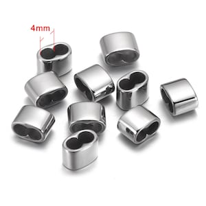 May include: Ten silver-toned metal bead caps with a 4mm opening. The bead caps are oval shaped and have a smooth finish.