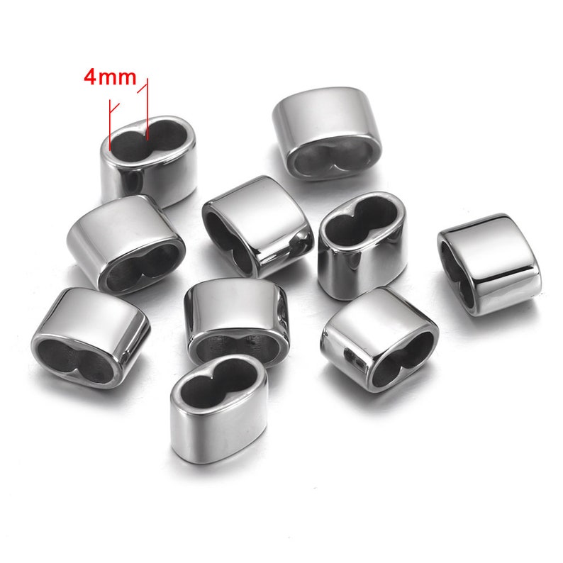 May include: Ten silver-toned metal bead caps with a 4mm opening. The bead caps are oval shaped and have a smooth finish.
