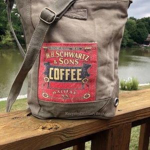 May include: A gray canvas tote bag with a vintage coffee label featuring the text "W.H. Schwartz & Sons Coffee Halifax N.S.". The bag has a long strap and a metal grommet on the side.