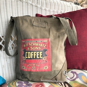 May include: A green canvas tote bag with a vintage coffee label sewn on the front. The label reads "W.H. Schwartz & Sons Coffee Halifax N.S."
