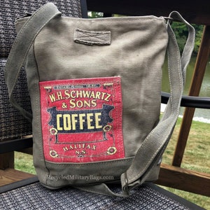 May include: A green canvas tote bag with a vintage coffee advertisement patch. The patch features the text "W.H. Schwartz & Sons Coffee" in red and yellow lettering. The bag has a long adjustable strap and is made from recycled materials.