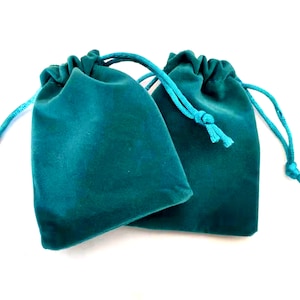 Puede incluir: Dos bolsitas de terciopelo azul turquesa con cordones de ajuste del mismo color.