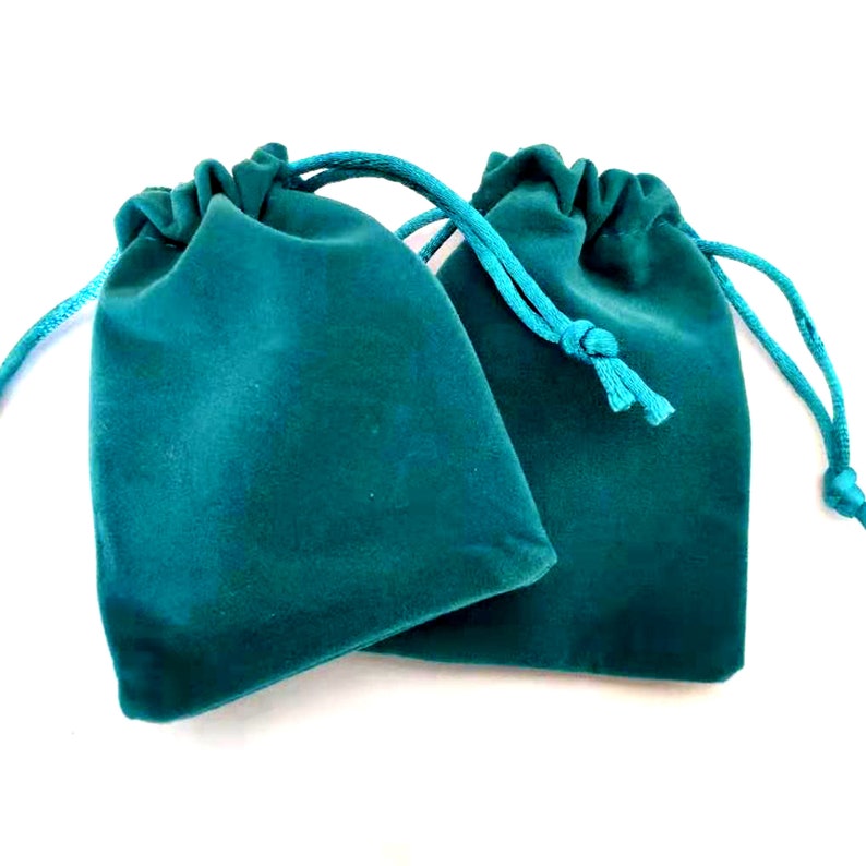 Puede incluir: Dos bolsitas de terciopelo azul turquesa con cordones de ajuste del mismo color.