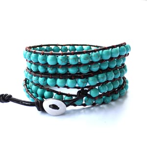 May include: A turquoise and brown leather wrap bracelet with a silver button closure.