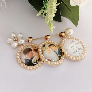 May include: A gold-toned brooch featuring three circular pendants framed with small white pearls. Two pendants contain photographs of a couple, while the third displays the text I walk with you today and everyday. A cluster of pearls accents the side.