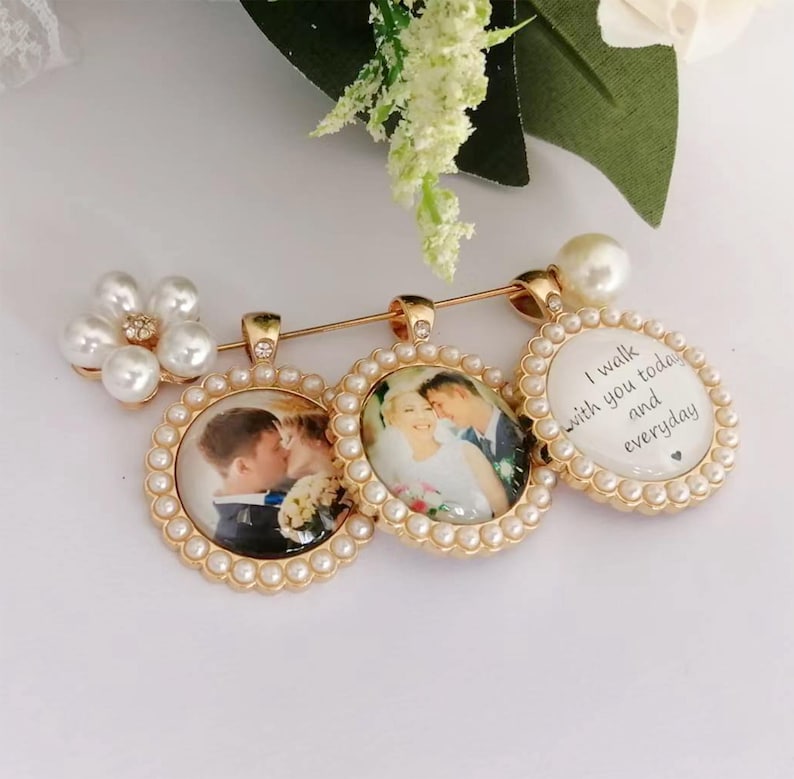 May include: A gold-toned brooch featuring three circular pendants framed with small white pearls. Two pendants contain photographs of a couple, while the third displays the text I walk with you today and everyday. A cluster of pearls accents the side.