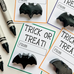 K&ouml;nnte beinhalten: Schwarze fledermausf&ouml;rmige Wachsmalstifte auf wei&szlig;en Karten mit dem Text "Trick or Treat!" und "From:" in Schwarz. Die Karten haben orange, gr&uuml;ne und lila R&auml;nder. Ein schwarz-wei&szlig;er Crayola-Buntstift ist im Hintergrund.