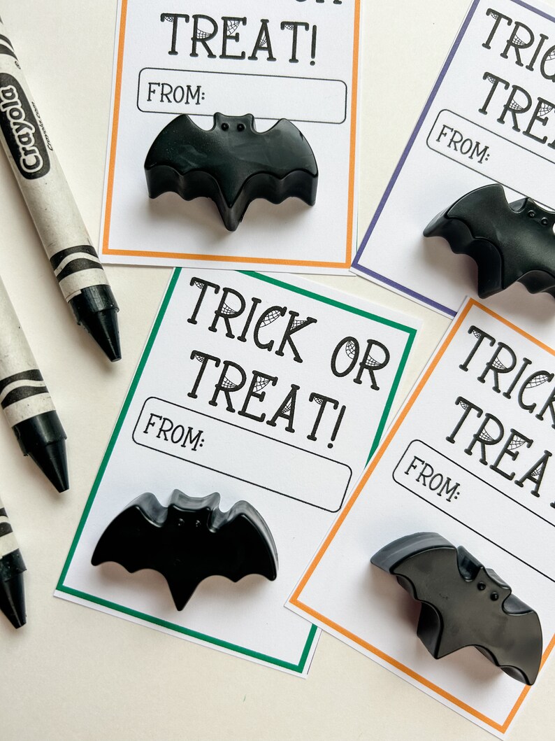 K&ouml;nnte beinhalten: Schwarze fledermausf&ouml;rmige Wachsmalstifte auf wei&szlig;en Karten mit dem Text "Trick or Treat!" und "From:" in Schwarz. Die Karten haben orange, gr&uuml;ne und lila R&auml;nder. Ein schwarz-wei&szlig;er Crayola-Buntstift ist im Hintergrund.
