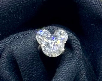 May include: A clear, faceted, Mickey Mouse-shaped diamond ring.