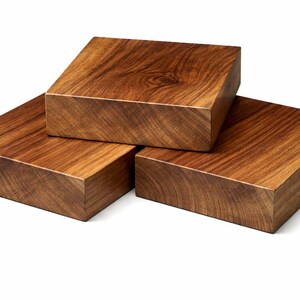 May include: Three square wooden blocks with a rich, warm brown color and visible wood grain. The blocks are stacked in a visually appealing arrangement, showcasing the natural beauty of the wood.