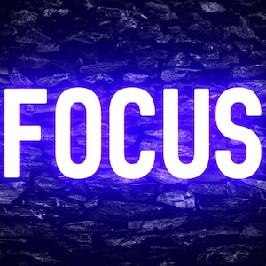 May include: The word "FOCUS" in white neon letters against a dark blue stone wall background.