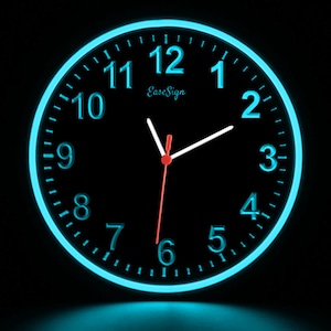 May include: A black clock with a blue neon rim and white hands. The clock face has white numbers and the text "Ease Sign" at the top.