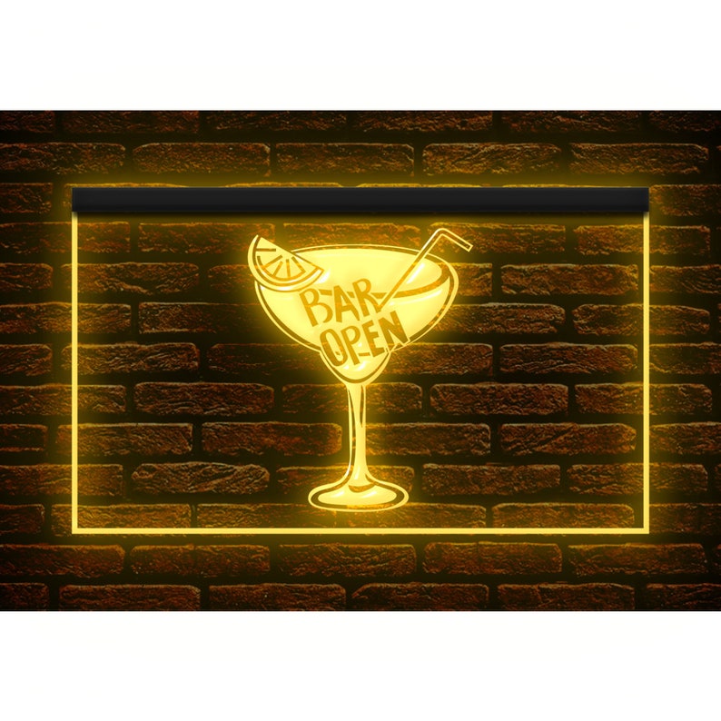May include: A neon sign with a yellow glow, featuring a cocktail glass design with a lemon slice and a straw. The words "BAR OPEN" are inside the glass. The sign is set against a brown brick wall.
