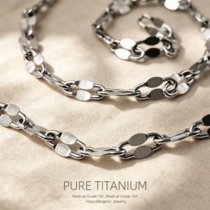 Pode incluir: Um colar de corrente em tom prateado com elos alongados de formato oval e acabamento polido. O texto PURE TITANIUM, Medical Grade TA1, Medical Grade TA1, Hypoallergenic Jewelry está impresso na parte inferior da imagem.