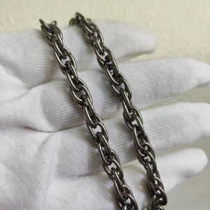 以下が含まれることがあります： ロープ状のデザインのシルバーチェーンネックレス。チェーンは複数の金属の糸がねじり合わされて作られています。