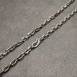 May include: A silver chain necklace with a lobster clasp closure.