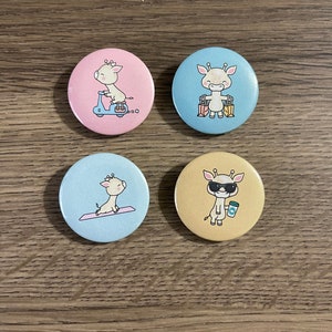May include: Four round button pins featuring a cartoon giraffe in different poses. The pins are on a wooden surface. The giraffe is wearing sunglasses, riding a scooter, holding shopping bags, and doing yoga.