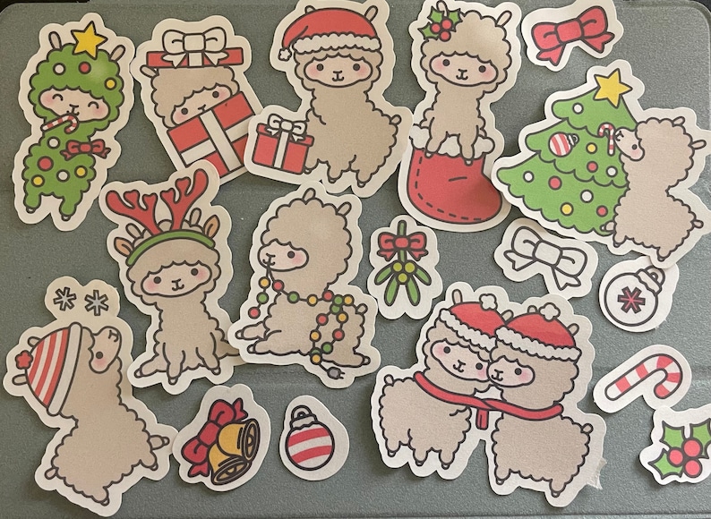 May include: A set of 14 Christmas-themed stickers featuring cute llama illustrations. The stickers feature various Christmas elements like a Christmas tree, ornaments, candy canes, and mistletoe. The llamas are wearing Santa hats, reindeer antlers, and other festive accessories.