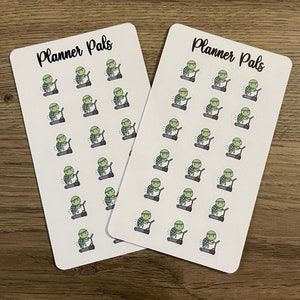 May include: Two sheets of white sticker paper with the text "Planner Pals" printed in black at the top. Each sheet has 20 stickers of a green turtle wearing a blue headband and running on a gray treadmill.