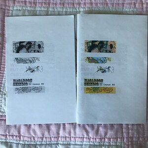 Op de afbeelding: Twee open zines getiteld "Macaroon Shindig Issue #6" worden getoond op een roze en witte quilt. Elke zine heeft een unieke collage van illustraties en tekst. De zines zijn wit met zwarte tekst en kleurrijke illustraties.