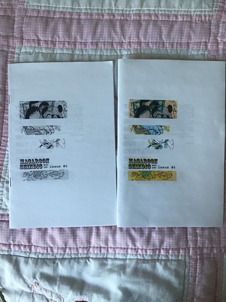 Op de afbeelding: Twee open zines getiteld "Macaroon Shindig Issue #6" worden getoond op een roze en witte quilt. Elke zine heeft een unieke collage van illustraties en tekst. De zines zijn wit met zwarte tekst en kleurrijke illustraties.