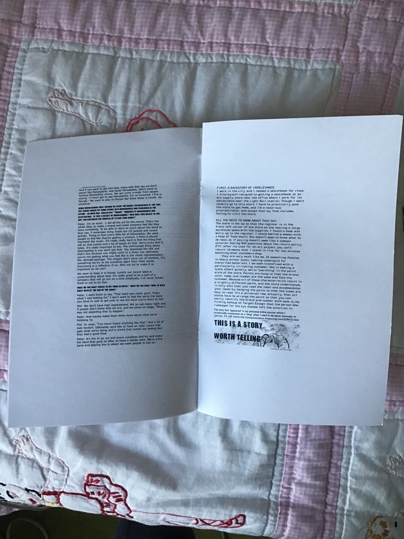Op de afbeelding: Een open boek met tekst op de pagina's, liggend op een roze en witte quilt. De rechterpagina heeft de tekst "THIS IS A STORY WORTH TELLING" in een zwart kader. De linkerpagina heeft ook tekst.