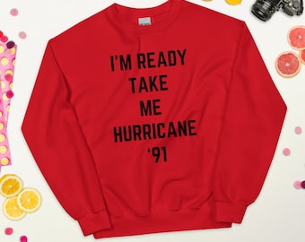 Könnte beinhalten: Roter Pullover mit schwarzem Text, der "I'm Ready Take Me Hurricane '91" lautet.