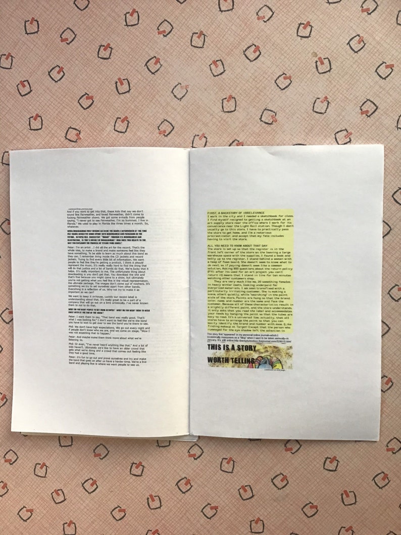 Op de afbeelding: Een open boek met zwarte tekst op de pagina's. Een kleine afbeelding met de tekst "THIS IS A STORY WORTH TELLING" staat op de rechterpagina. De achtergrond is een roze oppervlak met een patroon.
