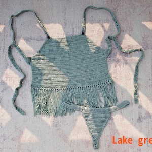Könnte beinhalten: Ein gehäkeltes Bikini-Oberteil und -Unterteil in der Farbe Seegrün. Das Oberteil hat einen Fransenbesatz und das Unterteil ist ein schlichter, hoch taillierter Stil.