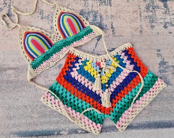 May include: A colorful crochet bikini set with a rainbow striped top and a multi-colored bottom. The top has a triangle shape and the bottom is a high-waisted short.