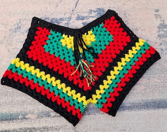 May include: A handmade crochet top in a square shape, featuring a vibrant color scheme of red, yellow, green, and black. The top has a fringed tie closure and is made with a granny square pattern. The garment is suitable for warm weather.