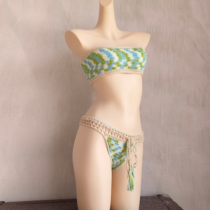 May include: A crocheted bikini top and bottom in a green and blue geometric pattern. The top is strapless and the bottom has a tie at the side.