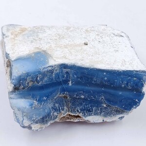 May include: A rough, blue and white, natural stone with a rough, irregular shape.