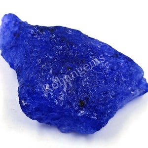 Può includere: Un grande cristallo blu ruvido con un aspetto traslucido. Il cristallo ha una forma irregolare e frastagliata.