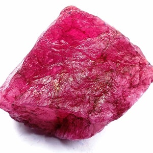 Puede incluir: Un gran cristal de rubí rosa en bruto con un color profundo y rico. El cristal tiene una superficie natural sin pulir.