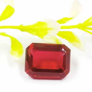 Peut inclure: Une pierre pr&eacute;cieuse de couleur rouge fonc&eacute;, taill&eacute;e en &eacute;meraude, avec un haut poli.