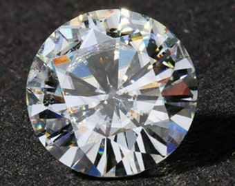 May include: A large, clear, round diamond with many facets. The diamond is set against a black background.