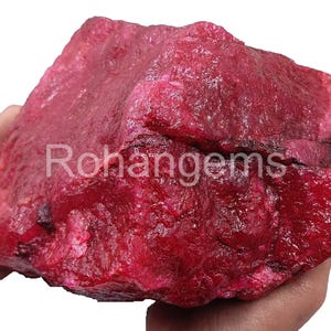 Peut inclure: Une grosse pierre précieuse de rubis rouge brut. Le rubis est d'une couleur rouge foncé et riche et a une surface naturelle non polie.
