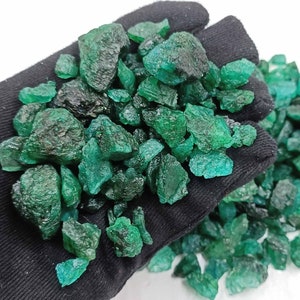 May include: A large pile of rough, green emerald gemstones. The emeralds are various sizes and shapes, and have a slightly translucent appearance.