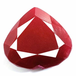 May include: A deep red heart-shaped gemstone with a faceted cut. The gemstone has a polished finish and is set in a silver setting.