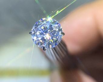 May include: A large, clear, round diamond with many facets, reflecting light.
