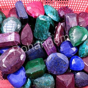 Puede incluir: Una colección de varias piedras preciosas en diferentes colores, incluyendo azul, verde, morado y rojo. Las piedras preciosas están dispuestas en una cesta y están listas para ser utilizadas para la elaboración de joyas u otras artesanías.