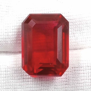 Peut inclure: Une pierre pr&eacute;cieuse de couleur rouge fonc&eacute; taill&eacute;e en &eacute;meraude avec un haut poli.